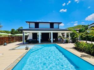 una casa con piscina di fronte a una casa di Villa Côté Sud a Sainte-Luce