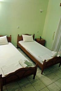 two beds in a room with green walls at Guesthouse Bizani in Neo Mpizani +10 photos