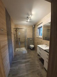 a bathroom with a shower and a toilet and a sink at Apartamenty Ambra in Dębina +221 photos