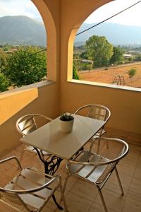 a white table and chairs in a room with a window at Guesthouse Bizani in Neo Mpizani