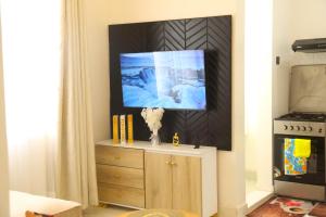 a tv sitting on top of a dresser in a living room at Edenville Thindigua Kiambu road in Nairobi