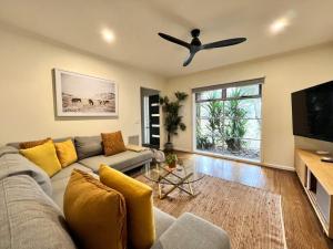a living room with a couch and a ceiling fan at Manna Gums- beautiful secluded setting in Daylesford