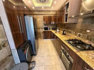 a large kitchen with a stove and a refrigerator at Villa Nagy in Madinaty