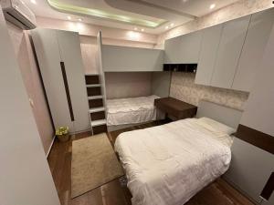 a small room with two beds and a bunk bed at Villa Nagy in Madinaty