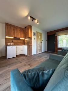 a living room with a couch and a kitchen at Słona Fala in Sianozety