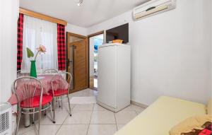 a dining room with a table and chairs and a refrigerator at Beautiful Apartment In Punta Kriza in Punta Križa