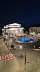 a large building with a fountain in front of it at night at Iggy Luxury Central Apartment in Hunedoara