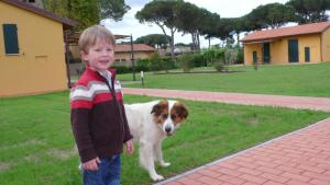 a young boy is standing next to a dog at La Fattoria di Tirrenia in Tirrenia