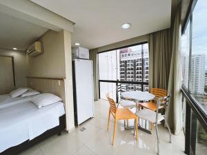 Una habitación de hotel con una cama, una mesa y sillas. en 1138 Flat Triplo Garvey - Esplanada e Congresso, en Brasilia