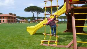 a young child playing on a slide at a park at La Fattoria di Tirrenia in Tirrenia