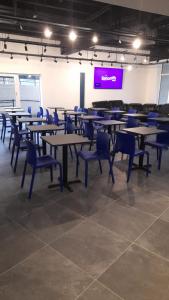 a room with tables and chairs and a projection screen at My Motel Glasgow Airport in Paisley
