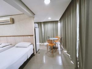 Una habitación de hotel con dos camas y una mesa y sillas. en 1138 Flat Triplo Garvey - Esplanada e Congresso, en Brasilia