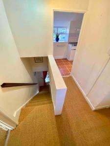 a white staircase in a room with a kitchen at Carefree Cottage in Marstow