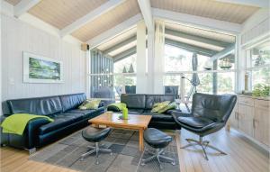a living room with a black leather couch and chairs at Holiday Home Odde Naturpark Vi in Helberskov
