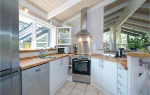 a kitchen with white cabinets and a stove top oven at Holiday Home Odde Naturpark Vi in Helberskov