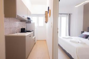 a small white kitchen with a bed and a sink at Malvina Homes Knossou in Áno Fortétsa