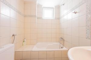 a white bathroom with a tub and a sink at Malvina Homes Knossou in Áno Fortétsa +17 photos