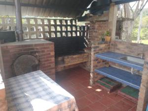 莫尼基拉Finca Hotel Posada La Riviera的室外厨房配有砖炉和水槽