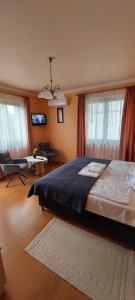 a bedroom with a bed and a living room at Arnika Vendégház in Hajdúszoboszló
