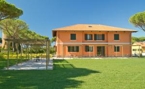 a house with a playground in front of a yard at La Fattoria di Tirrenia in Tirrenia