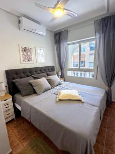 une chambre avec un grand lit avec un ventilateur de plafond dans l'établissement Torrevieja Seaside Escape, à Torrevieja 12 autres photos