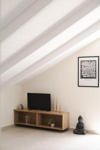 a living room with a flat screen tv on a table at White Lotus Loft & Apartments in Laganas