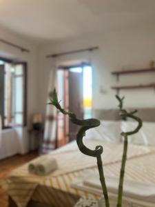 a plant in a vase next to a bed at Village House in Petaloú