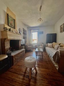 a living room with a couch and a fireplace at Village House in Petaloú