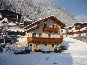 een gebouw met auto's in de sneeuw bij Apartment Christian in Mayrhofen