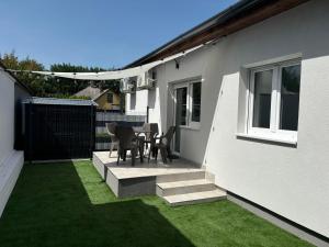 a patio with a table and chairs on the side of a house at SL Apartman Siófok in Siófok