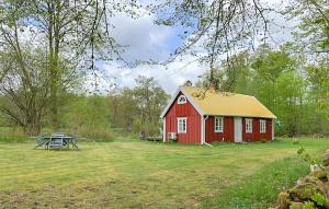 a red barn with a picnic table in a field at Holiday Home Linghult, Isaka Stuga Eldsberga in Plingshult