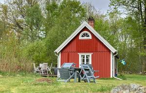 a red barn with chairs and a table in front of it at Holiday Home Linghult, Isaka Stuga Eldsberga in Plingshult