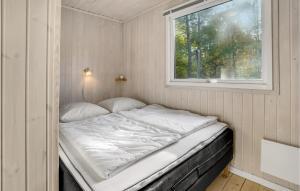 a bed in a small room with a window at Lovely Home In Hadsund With Kitchen in Hadsund +9 photos