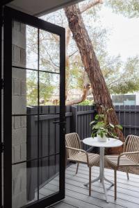 a patio with a table and chairs and a tree at MAC Richmond by Melbourne Apartment Collection in Melbourne
