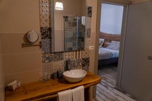a bathroom with a sink and a mirror at LOCANDA VECCHIO NOVECENTO in Grosso +17 photos