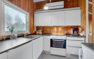 a kitchen with white cabinets and a window at Holiday Home Fjordparken Hadsund Iii in Odde
