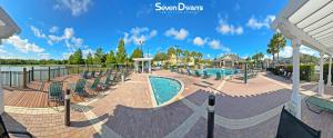 a swimming pool at a resort with chairs around it at Villas at Seven Dwarfs Resort - Near to Disney in Kissimmee
