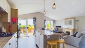 a kitchen and living room with a table and chairs at Poppy An Immaculate Lake side Lodge the Perfect Retreat, Sleeps 4 in Ryde