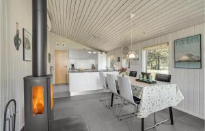 a kitchen and dining room with a fireplace in a house at Holiday Home Ingeborgvej Løkken Iv in Grønhøj