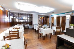 a dining room with white tables and chairs at San Marco Hotel in La Plata