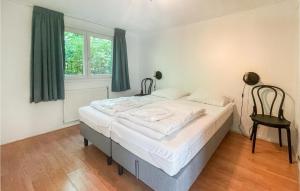 a bedroom with a bed and a chair in it at Lovely StaCaravan In Putten With Wifi in Putten +5 photos