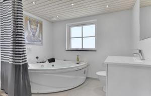a white bathroom with a tub and a toilet at Four-Bedroom Holiday Home In Bagenkop in Bagenkop