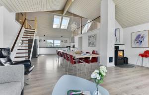 a living room with a table and red chairs at Four-Bedroom Holiday Home In Bagenkop in Bagenkop +21 photos