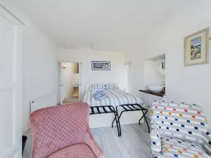 a bedroom with a bed and a pink chair at The Terrace in Portrush