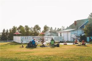 a group of people sitting in a yard with a dog at Island Life Cottages in Brackley Beach