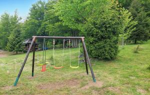 an empty swing set in a park with trees at Nice Home In Ravna Gora With Wifi in Ravna Gora +13 photos