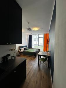 a living room with a bed and a desk in a room at Hotel Apart in Warsaw