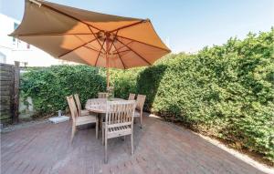 a table and chairs with an umbrella on a brick patio at Sea Level in De Panne