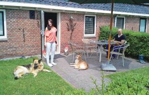 a woman standing in the doorway of a house with two dogs at Pet Friendly Apartment In Paesens in Paesens +3 photos