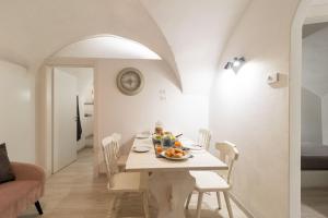 a white dining room with a table and chairs at VACANZE VICINO ALLE PISTE - Vicino a Parcheggio e Centro Benessere - Parco Naturale Adamello Brenta - WI-FI & Netflix in Caderzone Terme +19 photos